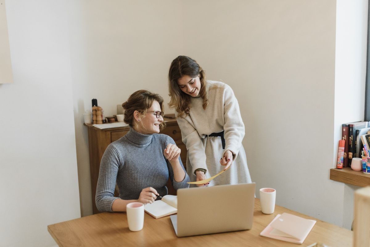 Two women working together at a small desk